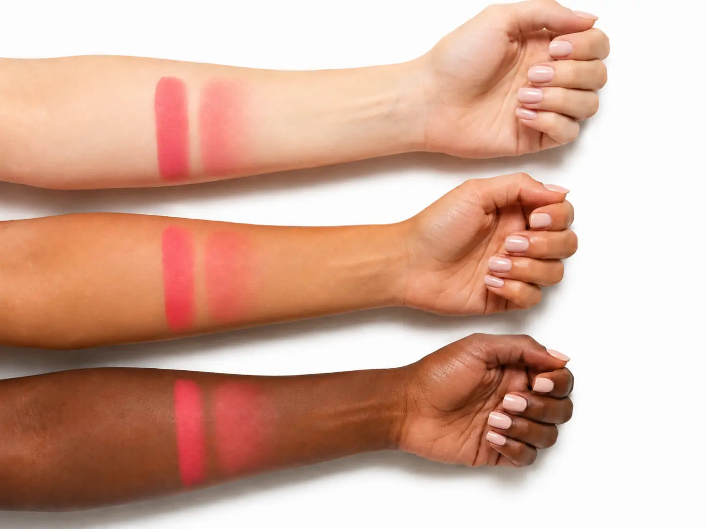 Amostra do Blush Stick Coral O Sfumato™ aplicada em três tons de pele sobre fundo branco.