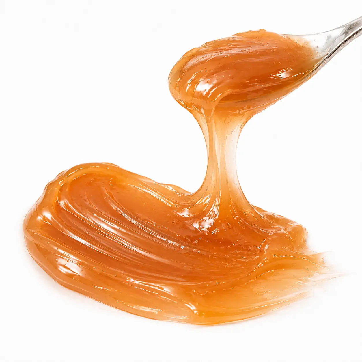 Close da textura âmbar da Máscara Labial Cobertura de Caramelo e Avelã O Sfumato™ sendo levantada com espátula transparente.