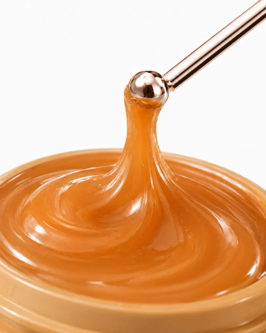 Close da textura cremosa e brilhante do bálsamo labial O Sfumato™ Caramel Pudding em tom caramelo.