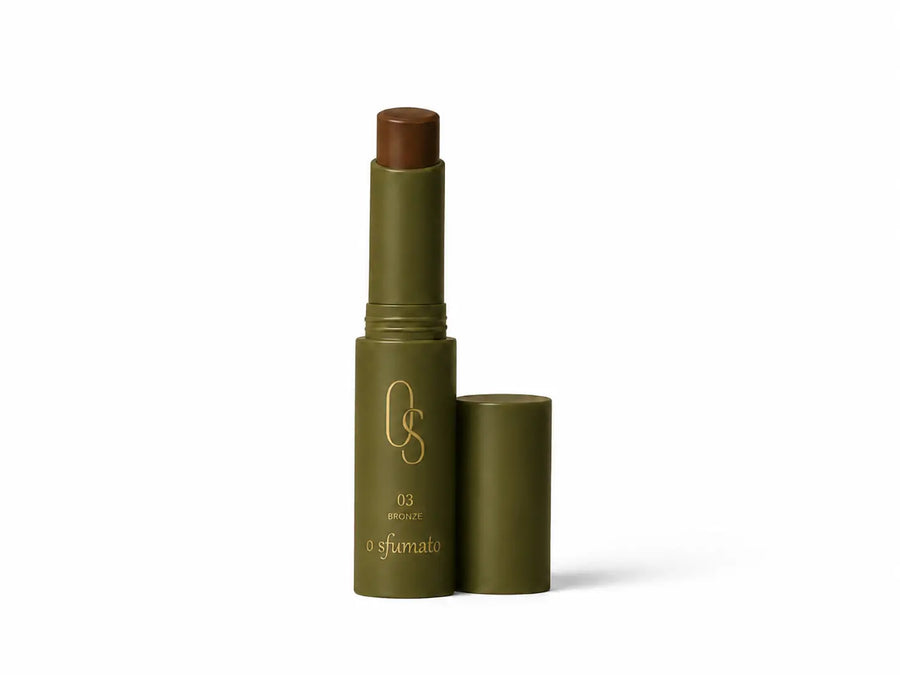 Corretivo em bastão O Sfumato™ Bronze com embalagem verde minimalista e acabamento elegante