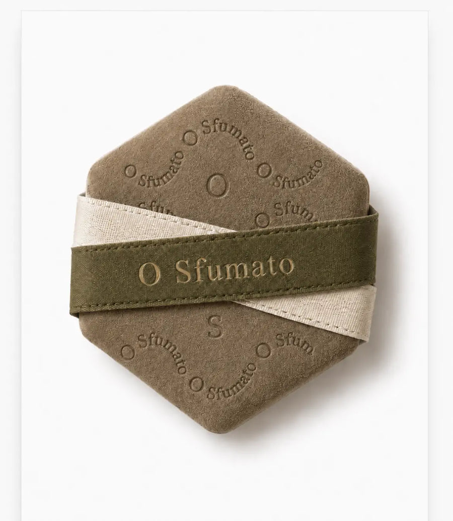 O Sfumato™ Puff de Maquiagem Hexagonal Cáqui com alça verde oliva sobre fundo branco