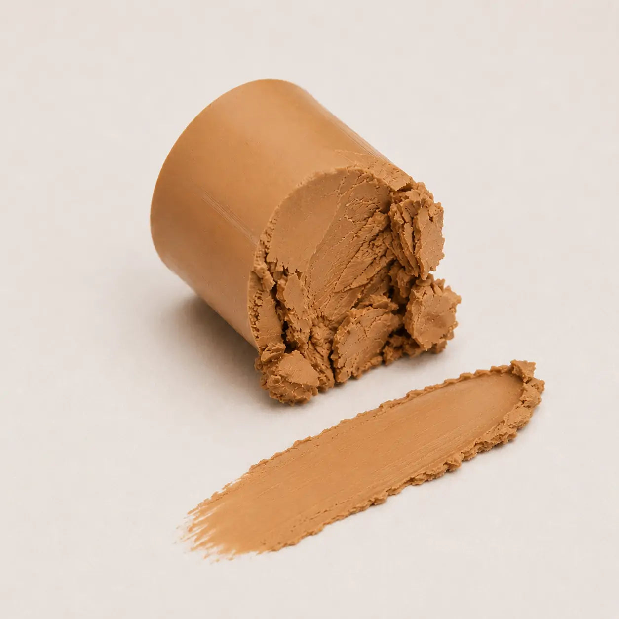 Textura cremosa do corretivo em bastão Honey com amostra espalhada e acabamento uniforme