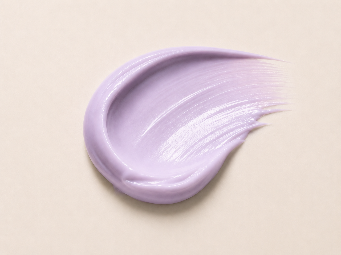 Textura cremosa lilás do primer facial O Sfumato™ espalhada sobre fundo bege